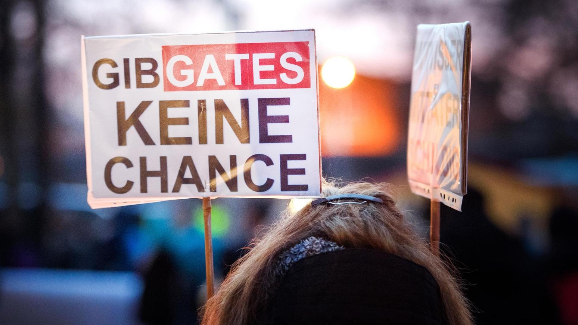 Gegner der Corona-Maßnahmen der Regierung stehen mit Schildern ("Gib Gates keine Chance") während einer Protestkundgebung auf dem Berta-Klingberg-Platz.