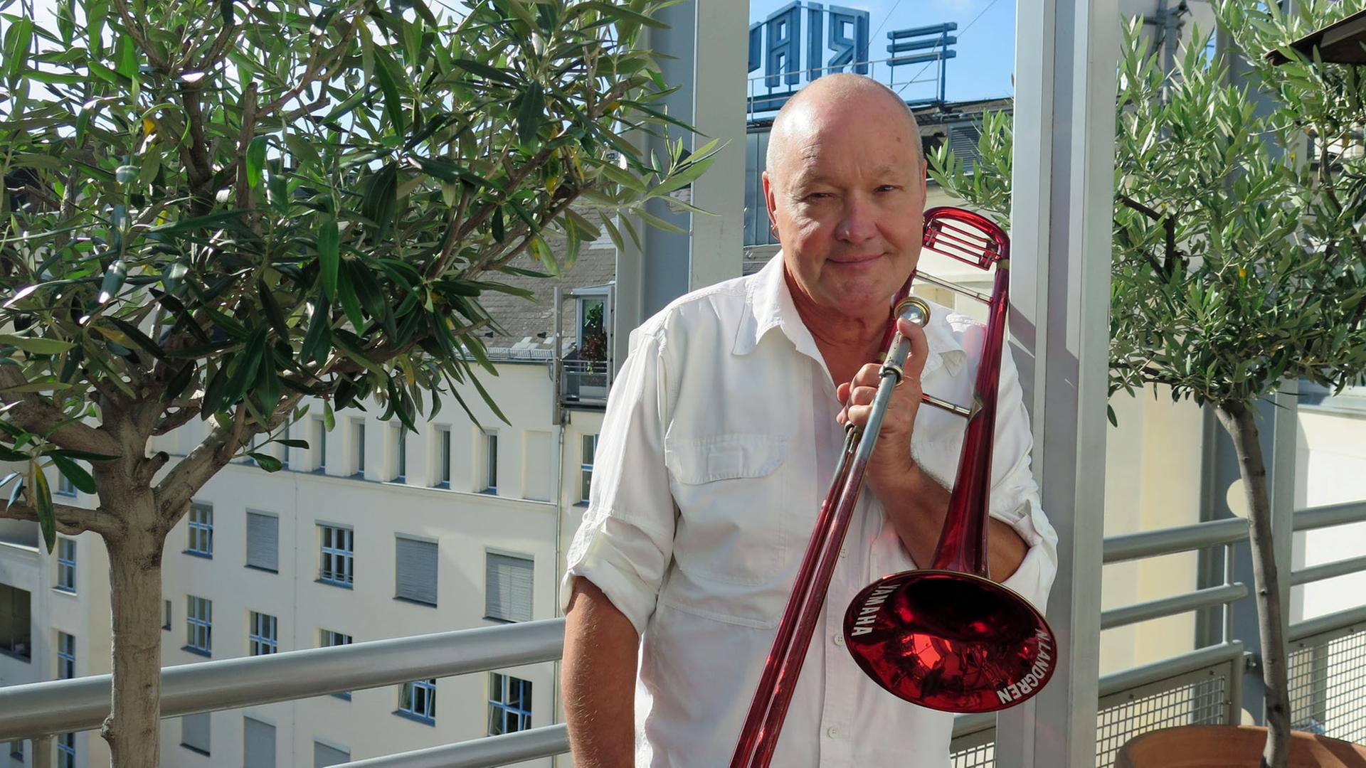 Der schwedische Jazzmusiker Nils Landgren steht mit seinem Markenzeichen, der roten Posaune, auf der Dachterasse von Deutschlandfunk Kultur. Der schwedische Jazzmusiker Nils Landgren steht mit seinem Markenzeichen, der roten Posaune, auf der Dachterasse von Deutschlandfunk Kultur.