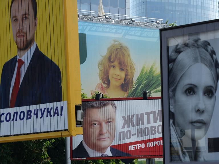 Wahlplakate in der Ukraine unter anderen Petro Poroschenko (M.) und Julia Timoschenko (r.) in einer Straße in Kiew.