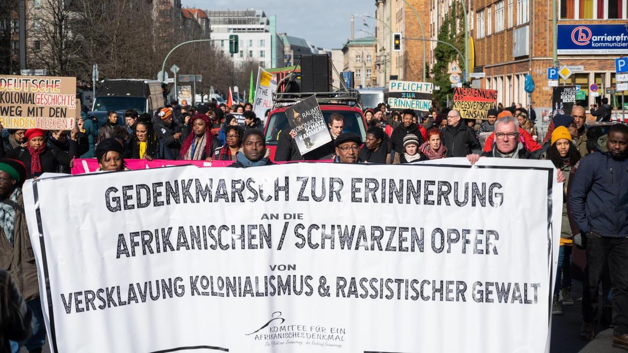 Gedenkmarsch für afrikanische Opfer von Versklavung Ende Februar 2020 in Berlin: Die Demonstranten halten Transparente, auf denen gegen rassistische Gewalt protestiert wird.