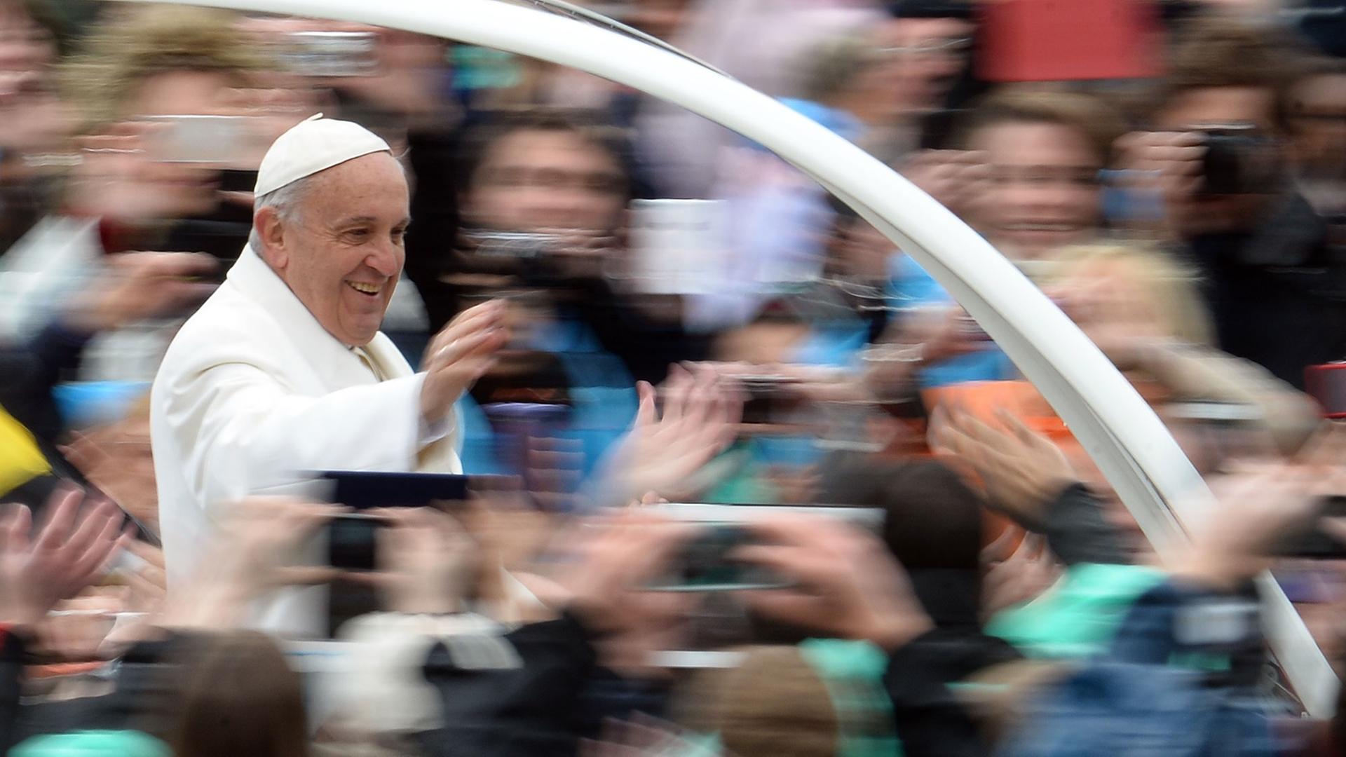 Papst Franziskus grüßt Menschen auf dem Petersplatz im Rom von seinem Papamobil aus. Papst Franziskus grüßt Menschen auf dem Petersplatz im Rom von seinem Papamobil aus.