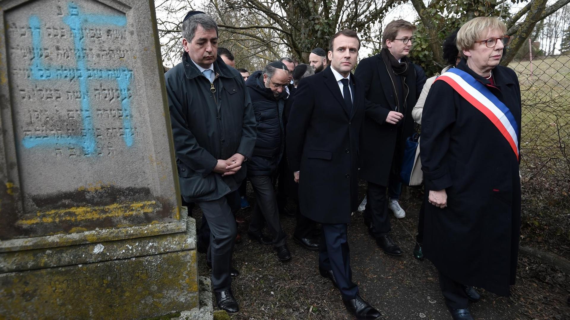 Frankreichs Präsident Emmanuel Macron beim Besuch eines jüdischen Friedhofs in Quatzenheim im Elsass, auf dem Grabsteine mit Hakenkreuzen beschmiert worden waren Frankreichs Präsident Emmanuel Macron beim Besuch eines jüdischen Friedhofs in Quatzenheim im Elsass, auf dem Grabsteine mit Hakenkreuzen beschmiert worden waren