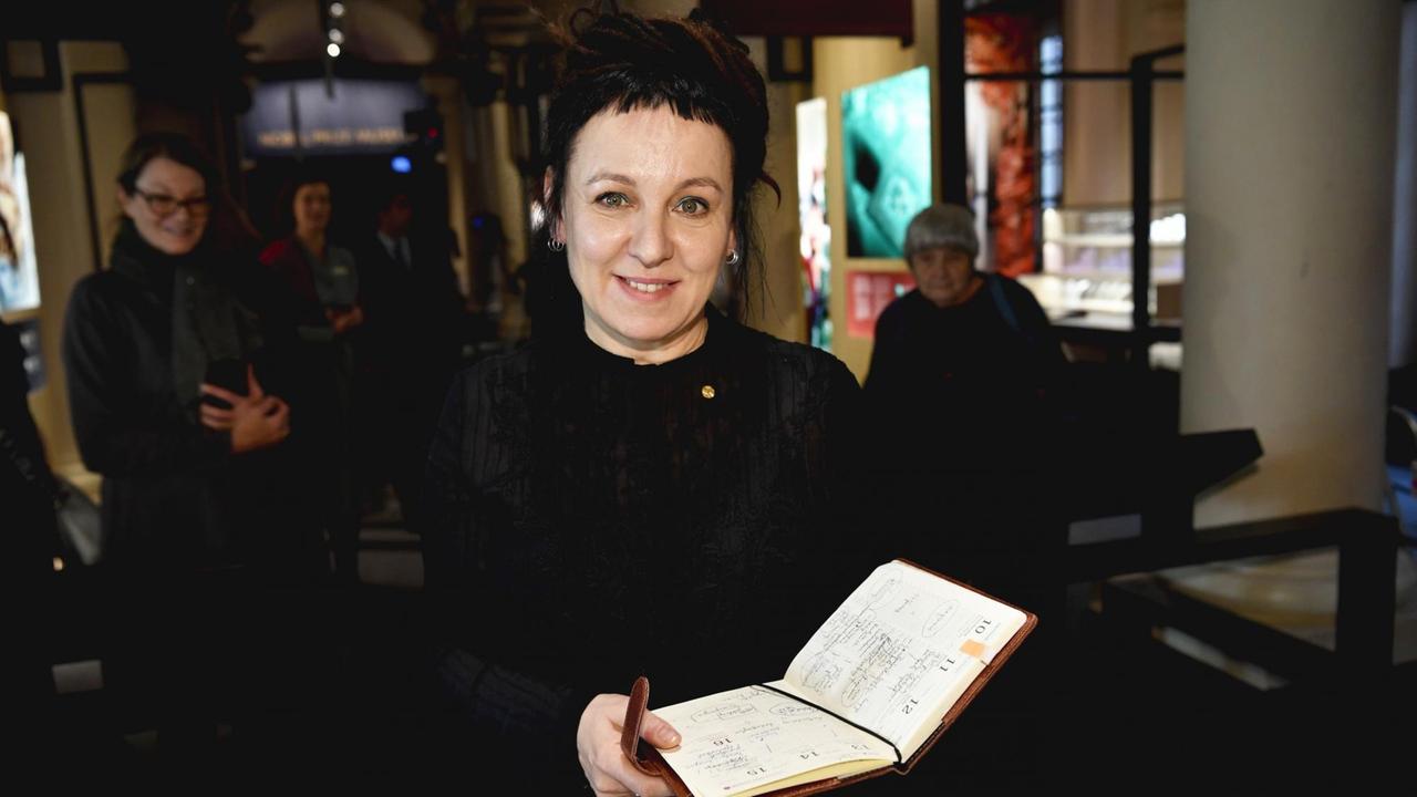 Literaturnobelpreisträgerin Olga Tokarczuk mit einem aufgeschlagenen Wochenkalender in der Hand. Literaturnobelpreisträgerin Olga Tokarczuk mit einem aufgeschlagenen Wochenkalender in der Hand.