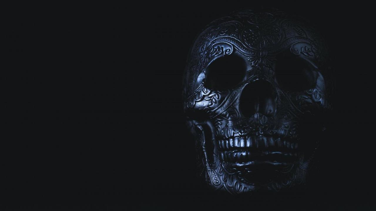 Großaufnahme eines mit Blumenranken und anderen Ornamenten verzierten Totenkopfs. Großaufnahme eines mit Blumenranken und anderen Ornamenten verzierten Totenkopfs.