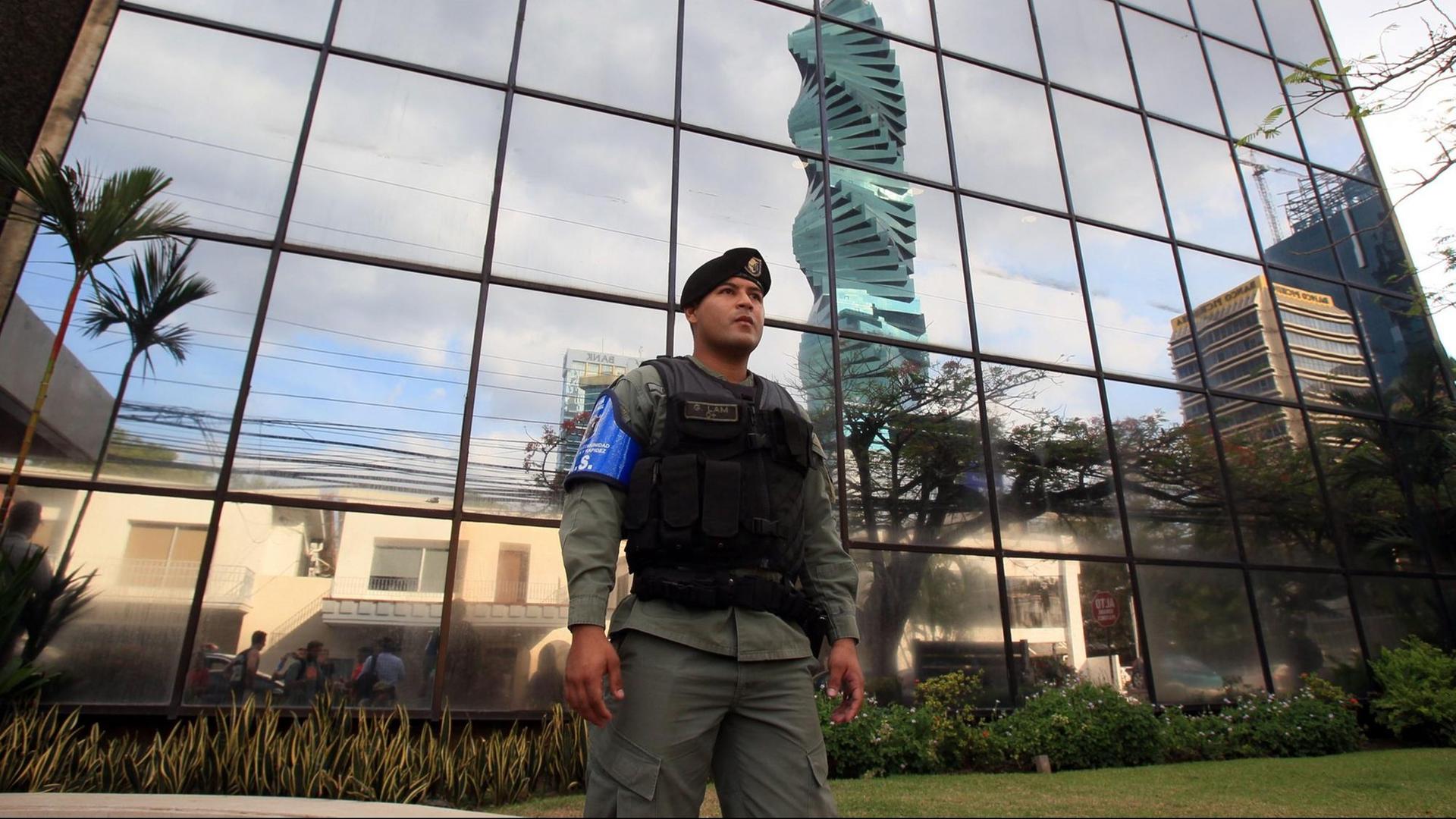 Ein Polizist steht vor einem Glasgebäude, der Zentrale der Kanzlei Mossack Fonseca in Panama City. Ein Polizist steht vor einem Glasgebäude, der Zentrale der Kanzlei Mossack Fonseca in Panama City.
