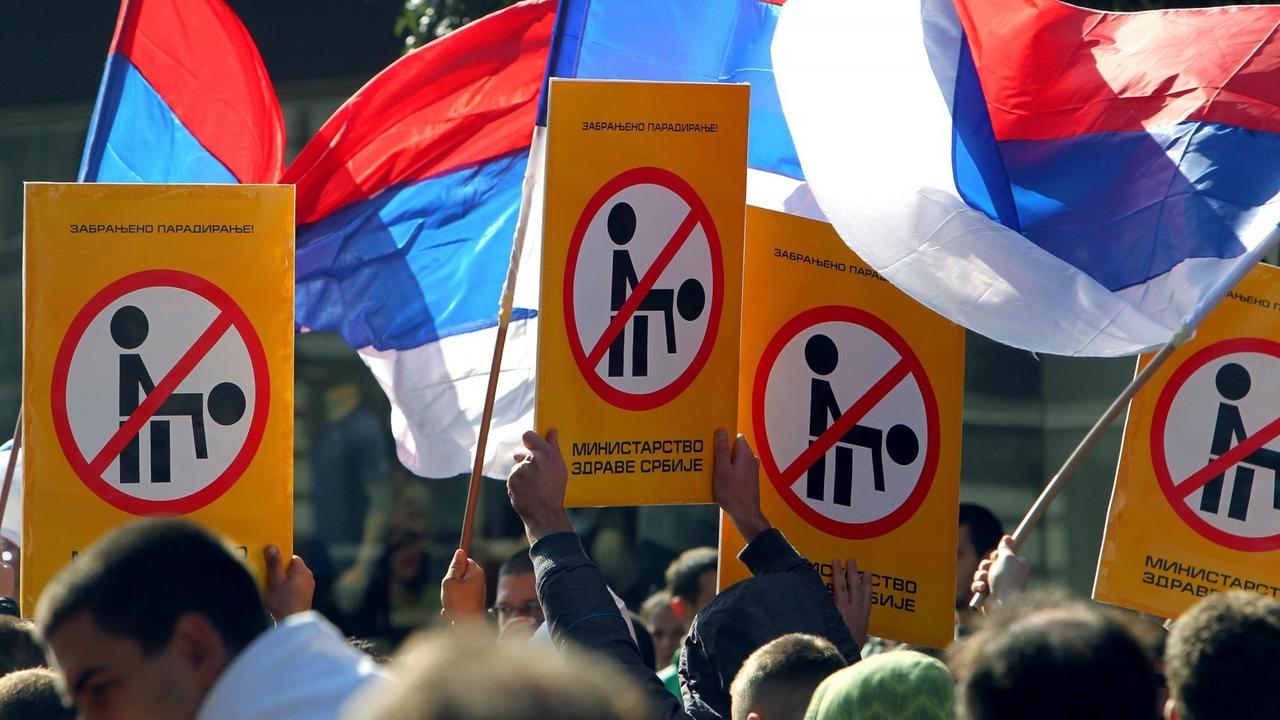 Bei einer Anti-Schwulen-Demonstration am 09. Oktober 2010 in Belgrad, halten Menschen serbische Flaggen und anti-schwule Transparente in der Hand.