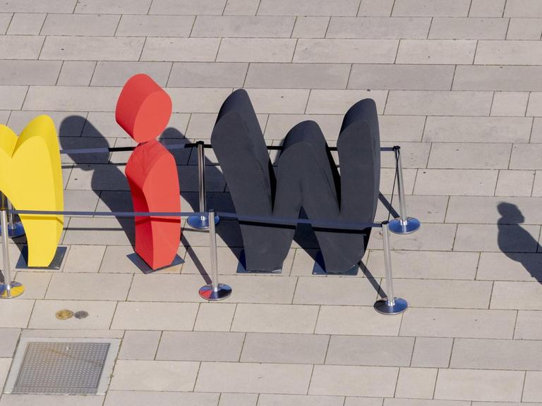 Das Wort "wir" steht als Teil der Freiluftausstellung EinheitsEXPO in schwarz-rot-gold gefärbten Buchstaben auf dem Stadtplatz Neuer Lustgarten in Potsdam.
