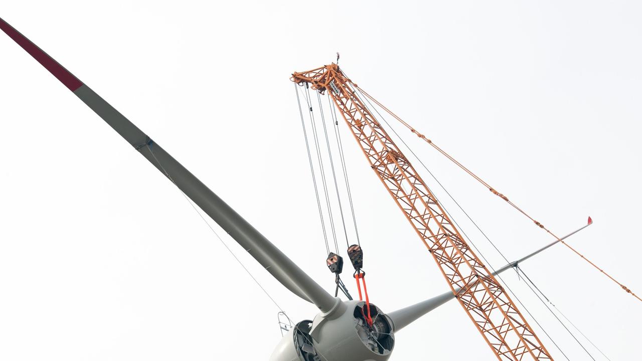 Der Propeller eines Windrades wird mithilfe eines Krans montiert. Der Propeller eines Windrades wird mithilfe eines Krans montiert.