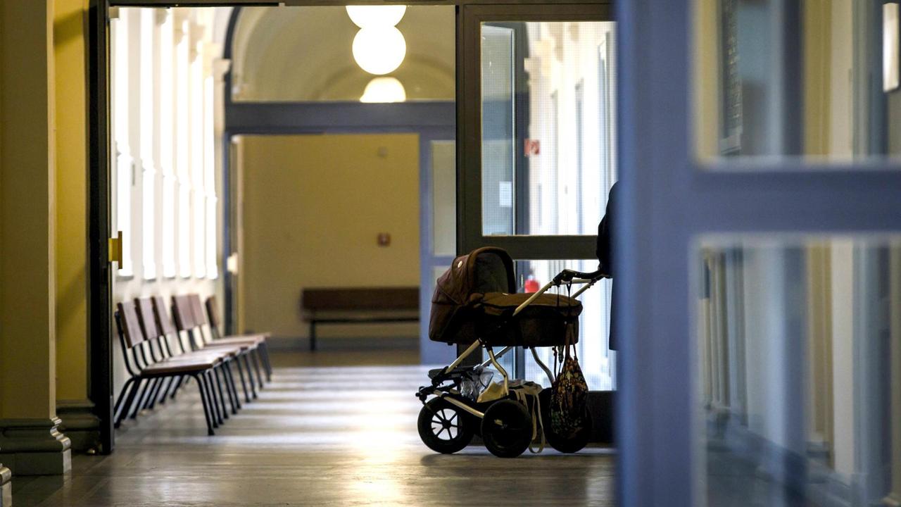 Im verlassen Gang vom Familiengericht steht eine Person mit Kinderwagen. Im verlassen Gang vom Familiengericht steht eine Person mit Kinderwagen.