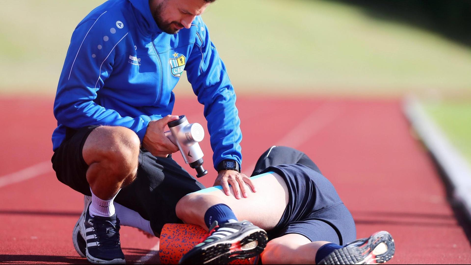 Physiotherapeut Florian Braband (Chemnitz) behandelt Torwart Joshua Mross (22, Chemnitz) mit einem Massagegerät, 5.7.2019. Physiotherapeut Florian Braband (Chemnitz) behandelt Torwart Joshua Mross (22, Chemnitz) mit einem Massagegerät, 5.7.2019.