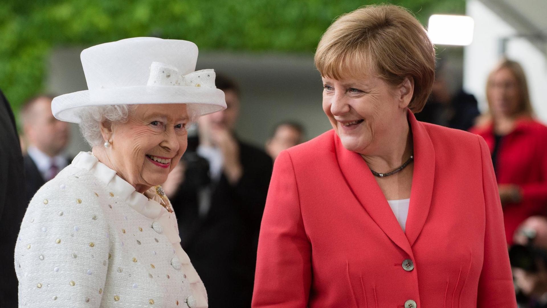 Die britische Königin Elizabeth II. (l) ganz in weiß und Bundeskanzlerin Angela Merkel im hellroten Jacket vor dem Kanzleramt.