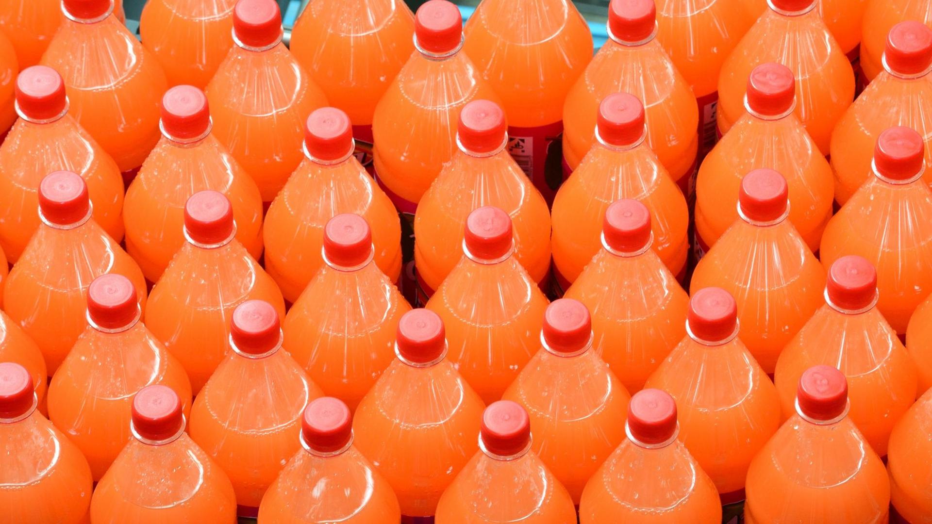 Limonaden-Flaschen werden auf einem Produktionsband weitertransportiert.