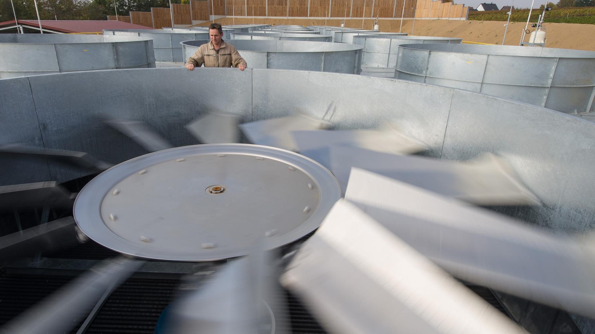 Ein Mitarbeiter steht in Insheim (Rheinland-Pfalz) in einem Geothermiekraftwerk neben einem großen Ventilator. Ein Mitarbeiter steht in Insheim (Rheinland-Pfalz) in einem Geothermiekraftwerk neben einem großen Ventilator.