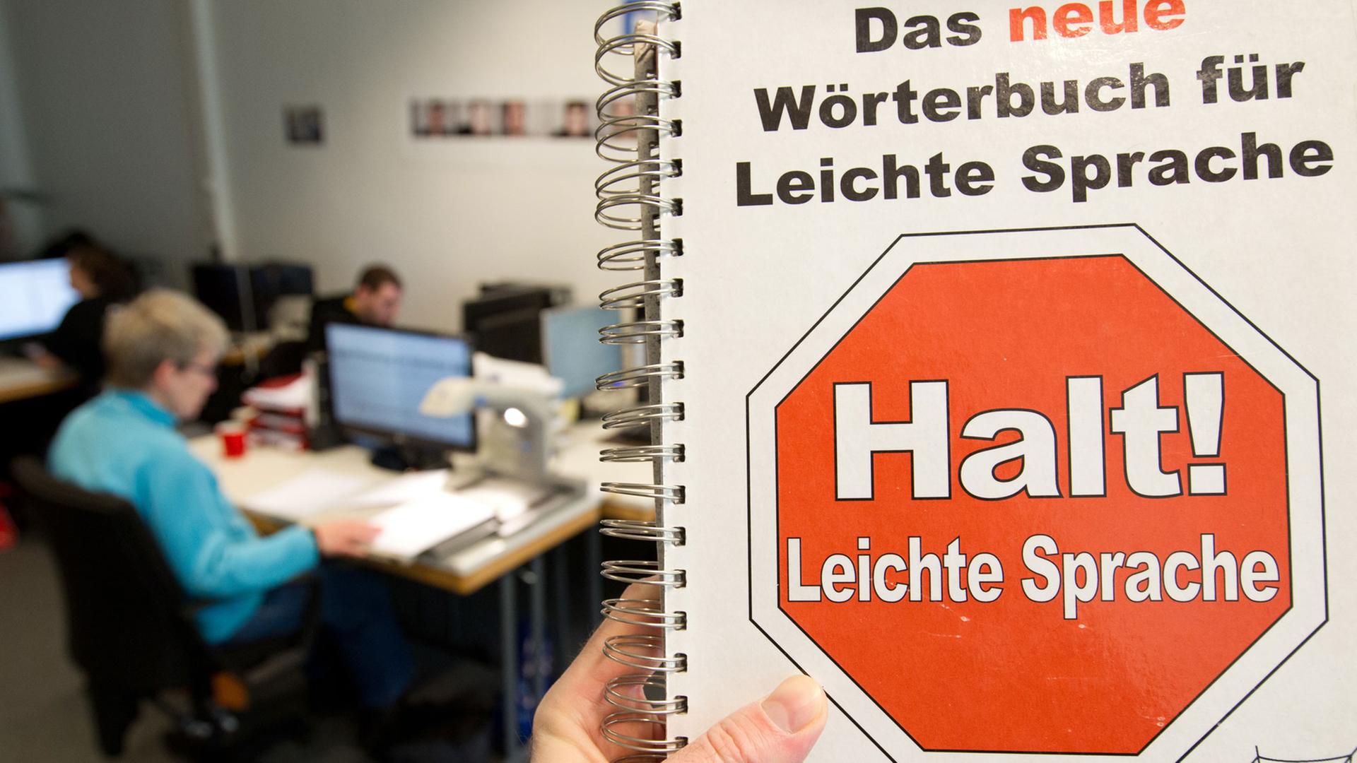 Eine Mitarbeiterin vom Büro für Leichte Sprache sitzt in der Hochschule Osnabrück vor einem Computermonitor - fotografiert am 6.1.2012 mit einem "Wörterbuch für Leichte Sprache". Eine Mitarbeiterin vom Büro für Leichte Sprache sitzt in der Hochschule Osnabrück vor einem Computermonitor - fotografiert am 6.1.2012 mit einem "Wörterbuch für Leichte Sprache".