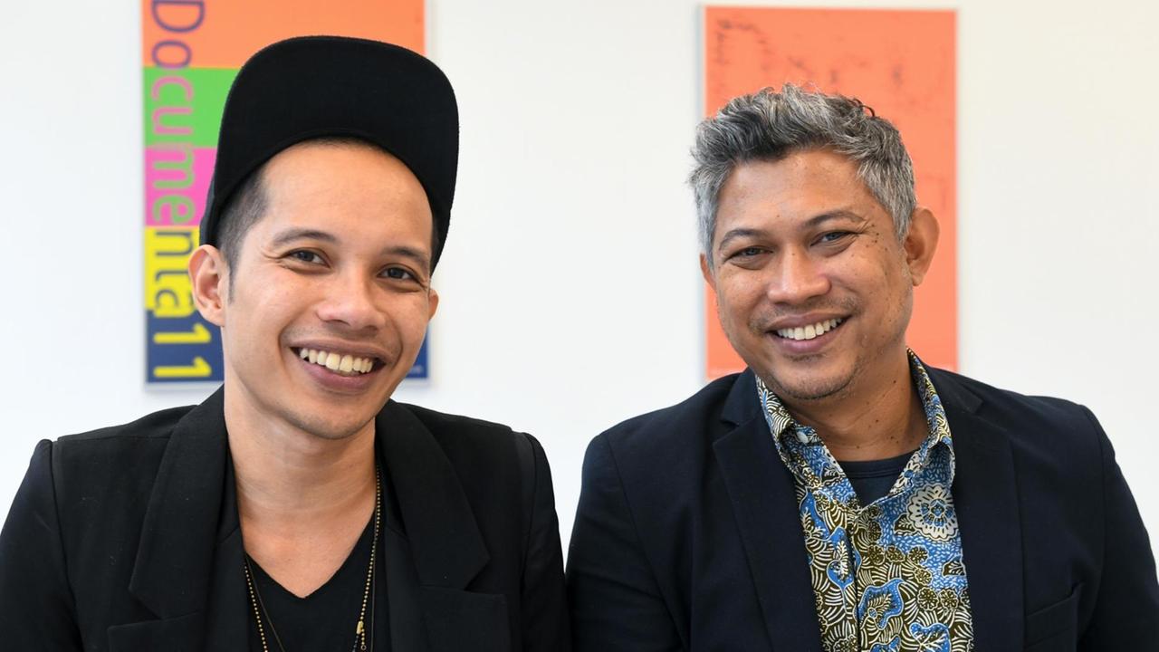 Die beiden Vertreter des indonesischen Künstlerkollektivs Ruangrupa, das die documenta 15 kuratieren wird, Farid Rakun (links) und Ade Darmawan, lächeln in Richtung der Kamera. Die beiden Vertreter des indonesischen Künstlerkollektivs Ruangrupa, das die documenta 15 kuratieren wird, Farid Rakun (links) und Ade Darmawan, lächeln in Richtung der Kamera.