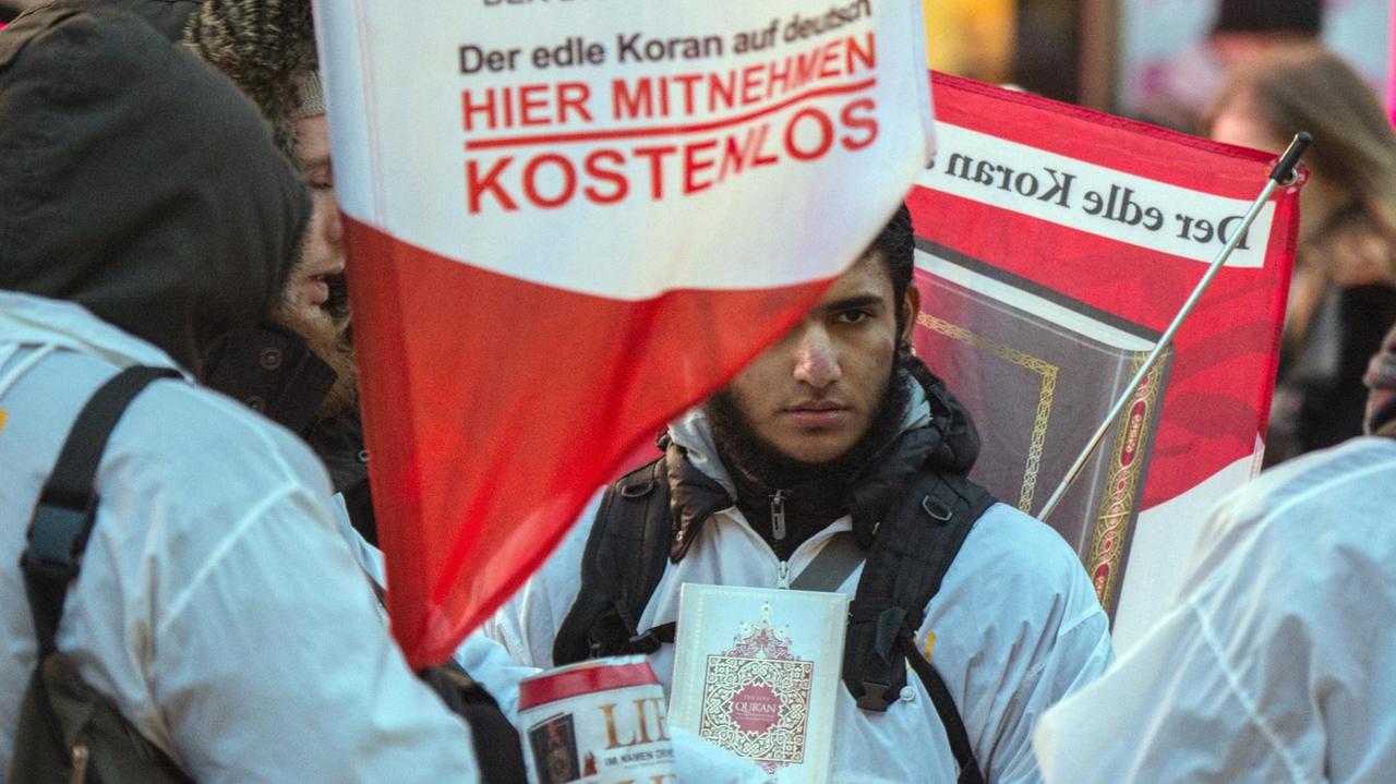 Mit einem Plakat auf dem Rücken versucht ein Teilnehmer der Koran-Verteilaktion "Lies" auf der Zeil in Frankfurt am Main (Hessen) die Aufmerksamkeit auf sich zu ziehen. Mit einem Plakat auf dem Rücken versucht ein Teilnehmer der Koran-Verteilaktion "Lies" auf der Zeil in Frankfurt am Main (Hessen) die Aufmerksamkeit auf sich zu ziehen.