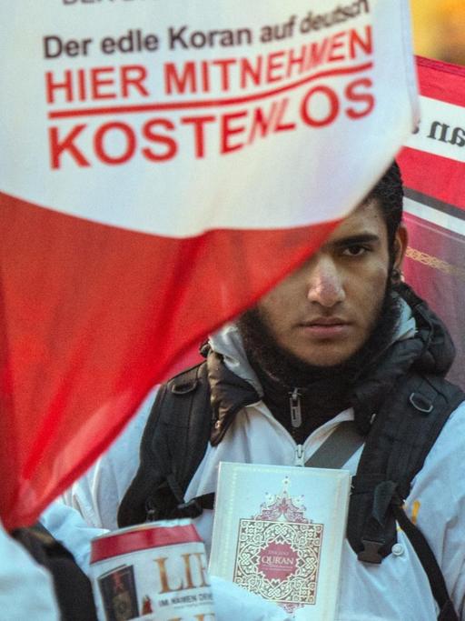 Mit einem Plakat versucht ein Teilnehmer der Koran-Verteilaktion "Lies" in Frankfurt am Main die Aufmerksamkeit auf sich zu ziehen. Aufnahme von Januar 2015.
