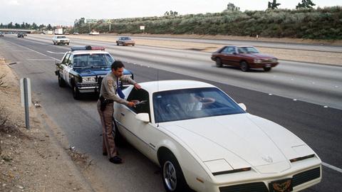Ein Polizist der California Highway Patrol gibt einem Verkehrssünder im Auto einen Strafzettel.