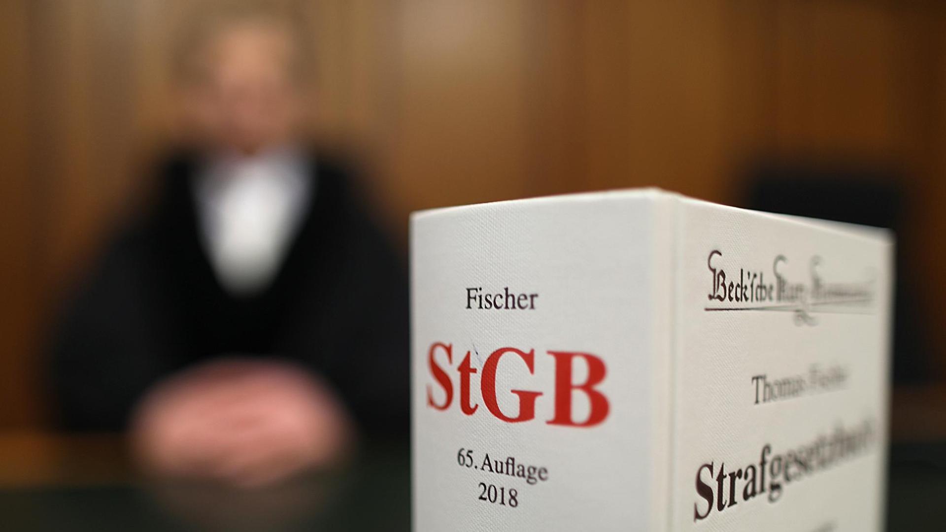 Ein Strafgesetzbuch (StGB) steht am 24.01.2018 in Köln (Nordrhein-Westfalen) im Oberlandesgericht auf der Richterbank.