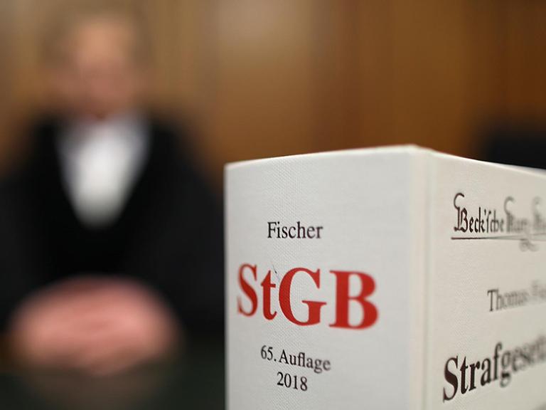 Ein Strafgesetzbuch (StGB) steht am 24.01.2018 in Köln (Nordrhein-Westfalen) im Oberlandesgericht auf der Richterbank.