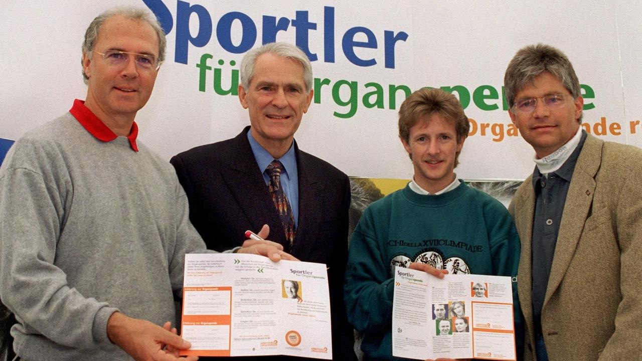 Die Initiatoren der Aktion "Sportler für Organspende" Franz Beckenbauer und Hans Wilhelm Gäb, langjähriger Präsident des Deutschen Tischtennis Bundes sowie der mehrmalige Olympiasieger im Skispringen, Jens Weißflog und Geher-Olympiasieger Hartwig Gauder (v.l.) präsentieren einen Organspenderausweis 1997. Die Initiatoren der Aktion "Sportler für Organspende" Franz Beckenbauer und Hans Wilhelm Gäb, langjähriger Präsident des Deutschen Tischtennis Bundes sowie der mehrmalige Olympiasieger im Skispringen, Jens Weißflog und Geher-Olympiasieger Hartwig Gauder (v.l.) präsentieren einen Organspenderausweis 1997.