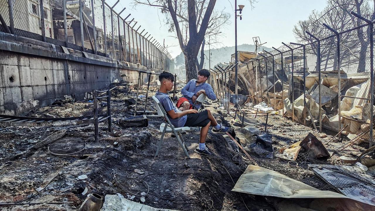 Das Foto zeigt Migranten im abgebrannten Lager von Moria. Das Foto zeigt Migranten im abgebrannten Lager von Moria.