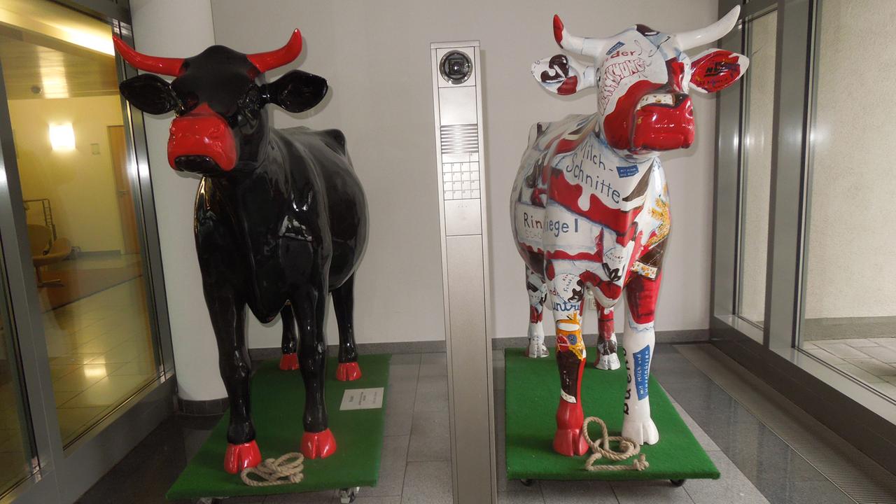 "Rinderüberraschung" - tierische Begrüßung im Eingang des Hauses für Land- und Ernährungswirtschaft. Zwei Kühe aus Plastik stehen im Eingangsbereich. 