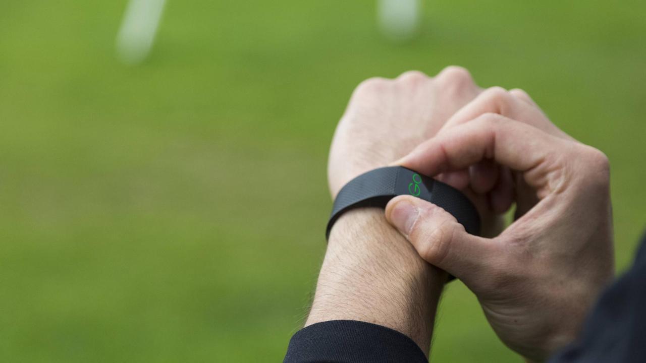 Ein Mann startet seinen Fitnesstracker, auf dem Display ist das Wort "Go" zu sehen. Ein Mann startet seinen Fitnesstracker, auf dem Display ist das Wort "Go" zu sehen.