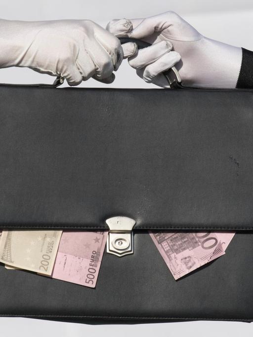 Eine Tasche mit heraushängenden Geldscheinen geht von einer Hand in die andere.