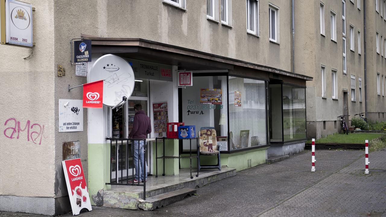 Ein Kunde steht vor dem Kiosk von Herr Turkut am Donnerstag (19.07.2012) in Dortmund Eving. Bier, Lakritz und Kreuzworträtsel: Kioske bietet alles für den schnellen Einkauf. Vor über 150 Jahren entstanden viele zum Verkauf von Mineralwasser. Doch die kleinen Buden sterben aus. Foto: Marcus Simai. Ein Kunde steht vor dem Kiosk von Herr Turkut am Donnerstag (19.07.2012) in Dortmund Eving. Bier, Lakritz und Kreuzworträtsel: Kioske bietet alles für den schnellen Einkauf. Vor über 150 Jahren entstanden viele zum Verkauf von Mineralwasser. Doch die kleinen Buden sterben aus. Foto: Marcus Simai.