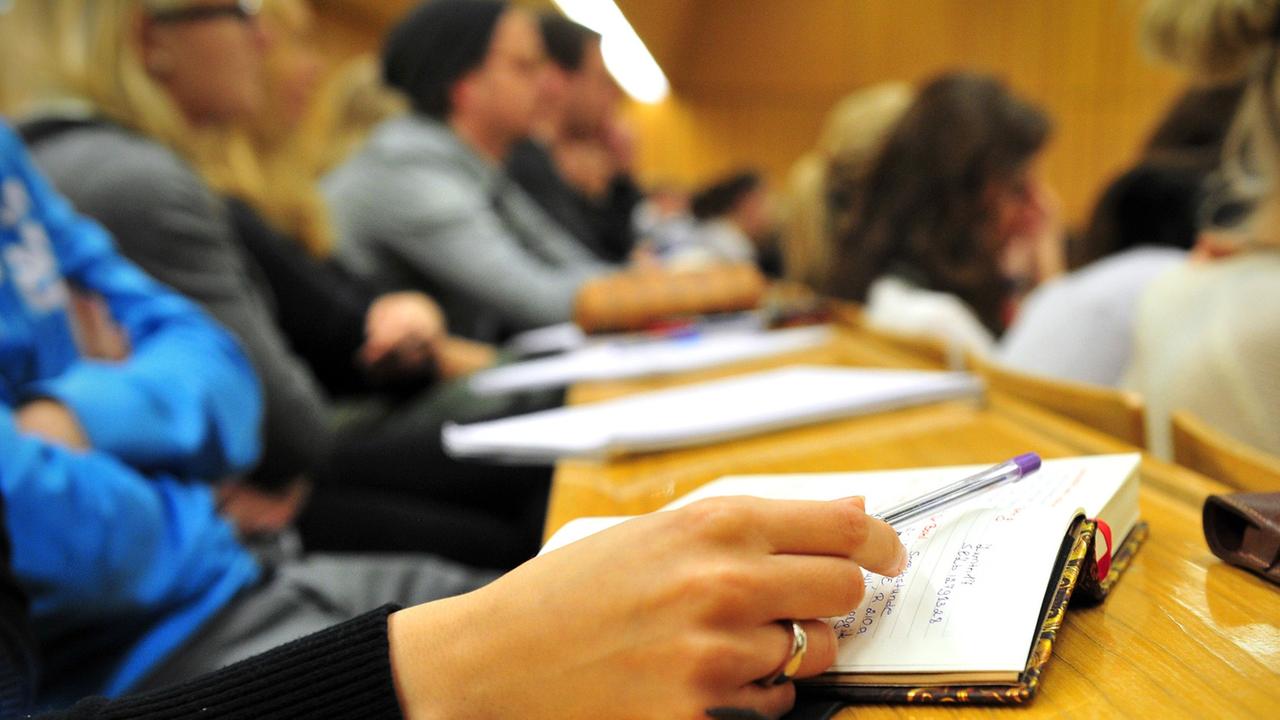 Eine Studentin der Schulpädagogik schreibt am 17.10.2012 während einer Vorlesung in einem vollen Hörsaal in der Universität in Tübingen (Baden-Württemberg) mit. Eine Studentin der Schulpädagogik schreibt am 17.10.2012 während einer Vorlesung in einem vollen Hörsaal in der Universität in Tübingen (Baden-Württemberg) mit.
