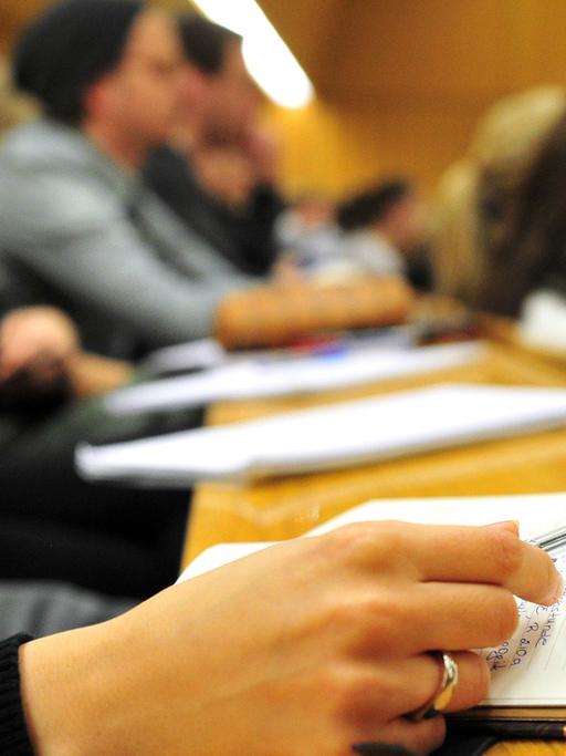 Eine Studentin der Schulpädagogik schreibt am 17.10.2012 während einer Vorlesung in einem vollen Hörsaal in der Universität in Tübingen (Baden-Württemberg) mit.