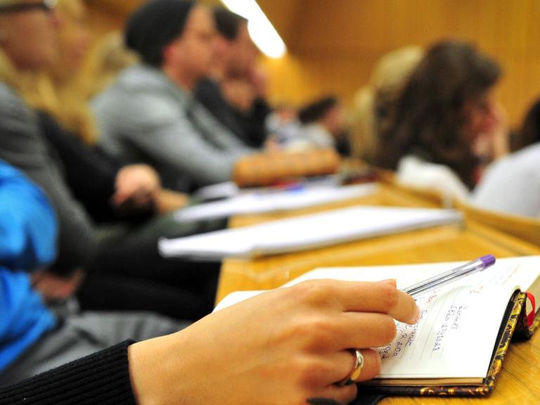 Eine Studentin der Schulpädagogik schreibt am 17.10.2012 während einer Vorlesung in einem vollen Hörsaal in der Universität in Tübingen (Baden-Württemberg) mit.
