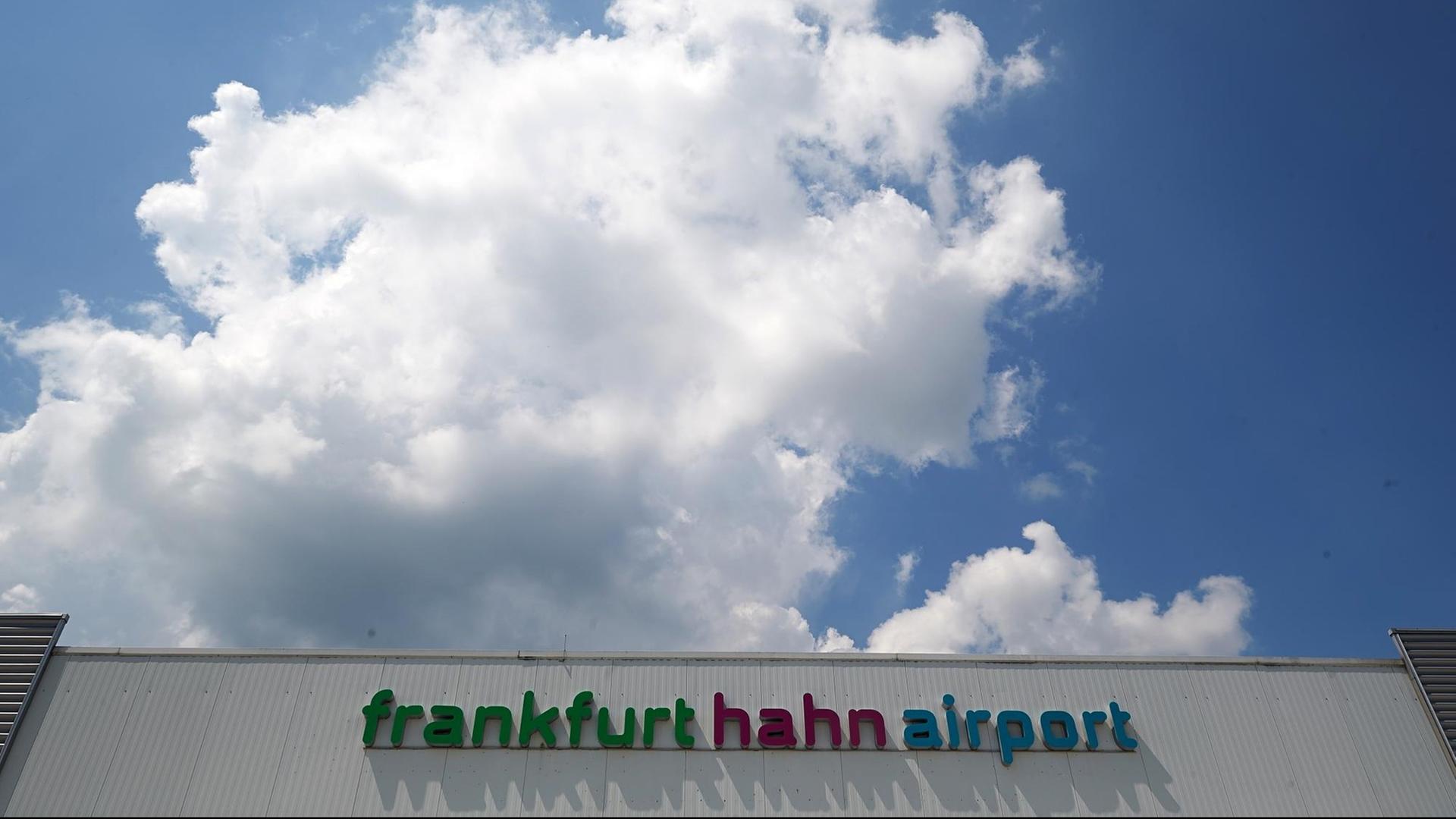 Die Aufschrift "frankfurt hahn airport" prangt auf einem Gebäude, darüber blauer bewölkter Himmel