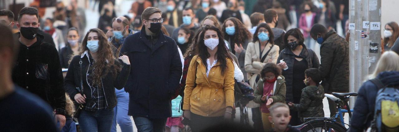 Menschen mit Masken laufen durch die Fußgängerzone Neuhauser Straße am Karlstor in der Innenstadt von München. Menschen mit Masken laufen durch die Fußgängerzone Neuhauser Straße am Karlstor in der Innenstadt von München.