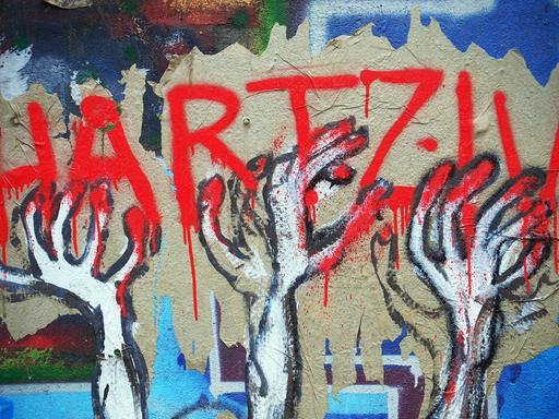 Ein unbekannter Street-Art-Künstler hat auf einer Mauer an einem besetzten Haus in Berlin im Bezirk Mitte dieses Bild geschaffen, das seine Meinung zu den Hartz IV Gesetzen drastisch wiedergibt, aufgenommen am 17.05.2014.