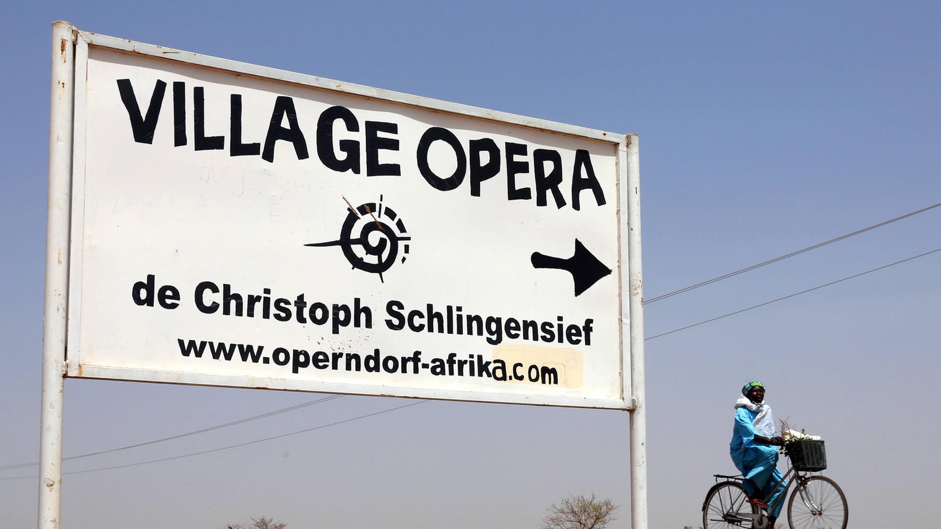 Hinweisschild zu Christoph Schlingensiefs Operndorf in Burkina Faso Hinweisschild zu Christoph Schlingensiefs Operndorf in Burkina Faso