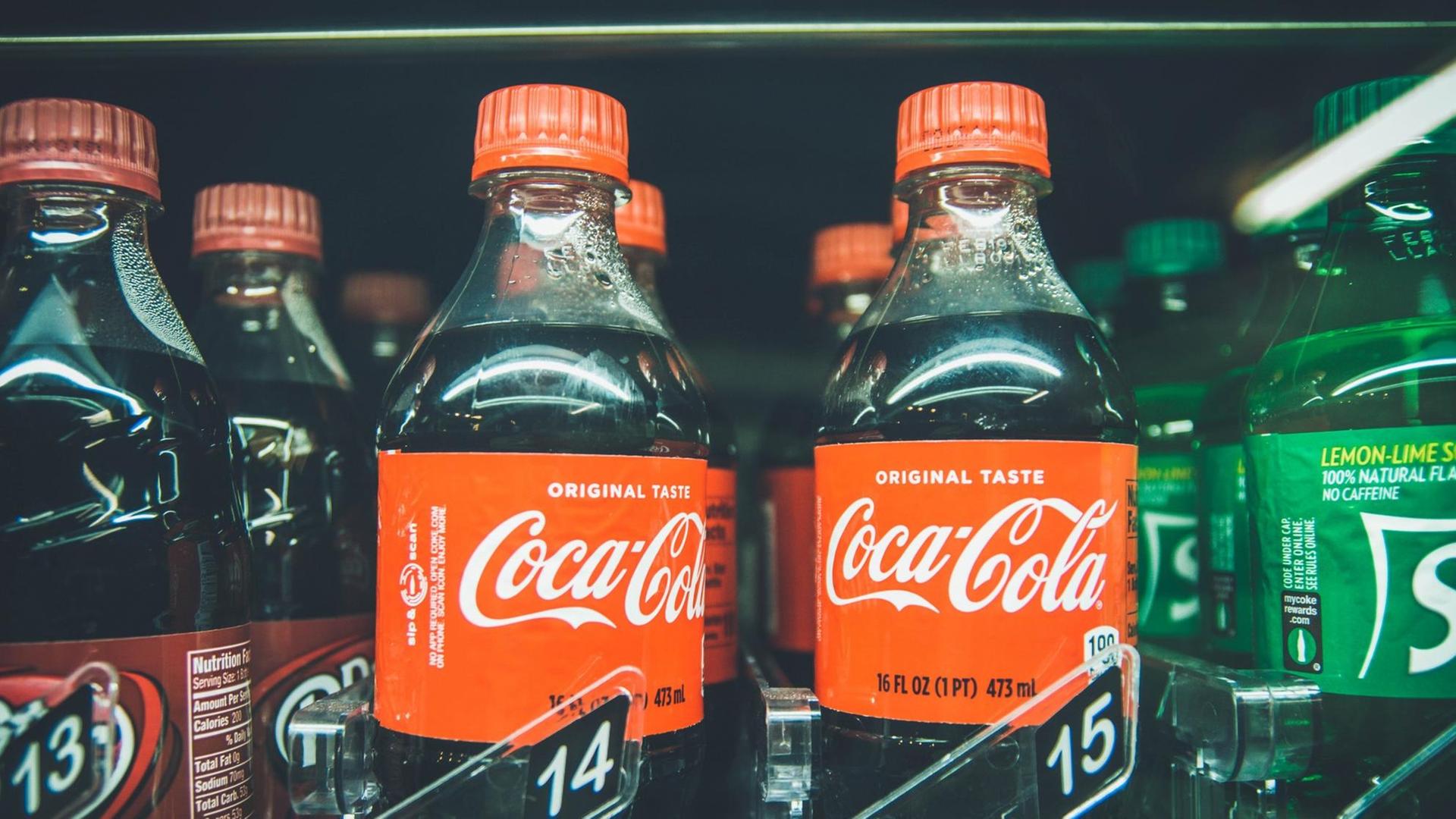 Verschiedene Flaschen, u.a. von Coca-Cola, stehen in einem Regal zum Verkauf. Verschiedene Flaschen, u.a. von Coca-Cola, stehen in einem Regal zum Verkauf.