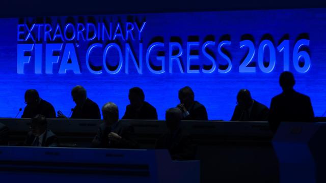 Schwarze Silhouetten vor einer blauen Wand, auf der "Extraordinary FIFA Congress 2016" steht.