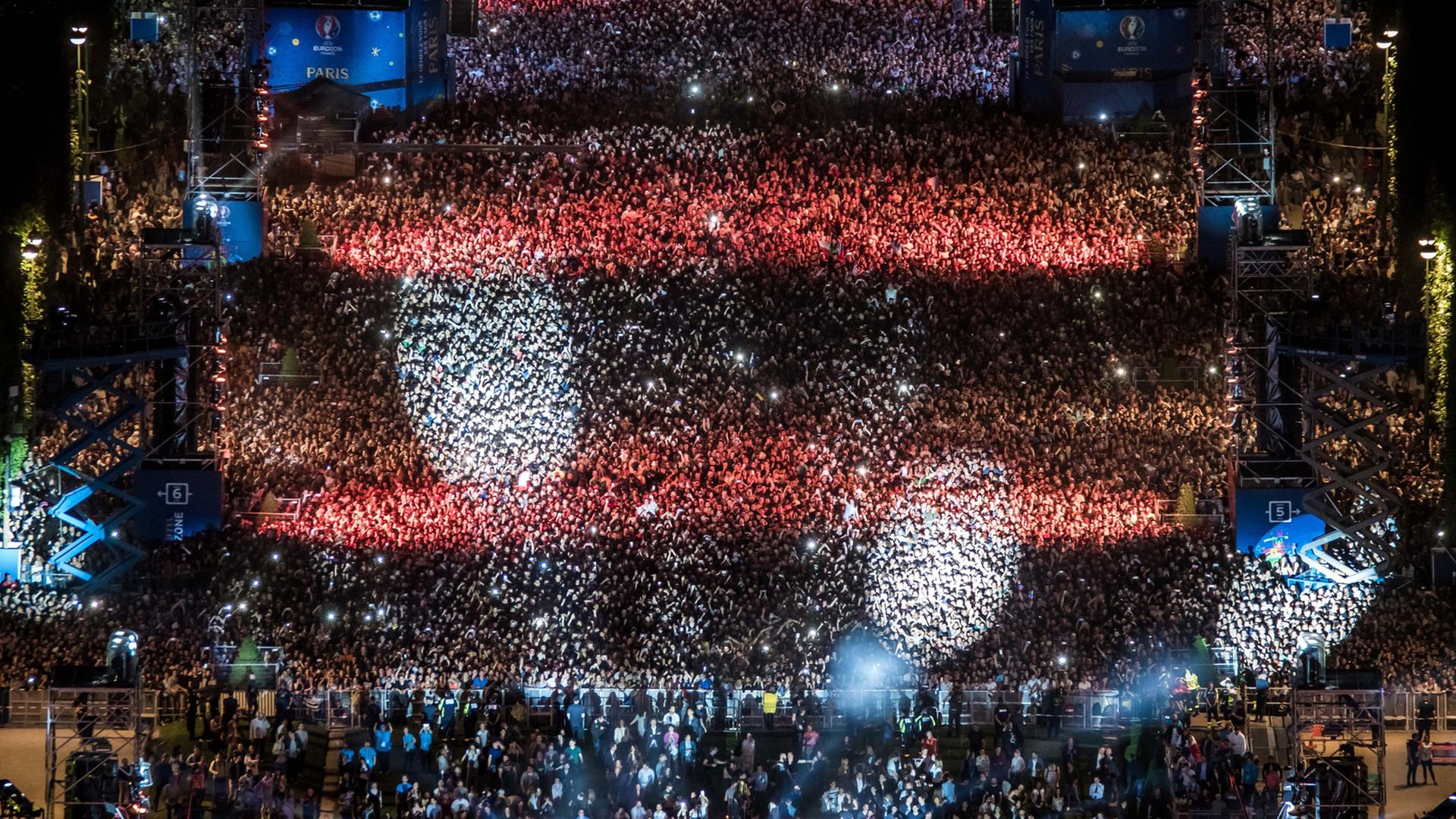 Fans verfolgen eine Pre-Opening-Show zur Fußball-EM in der Fanzone am Eiffelturm mit DJ David Guetta. Fans verfolgen eine Pre-Opening-Show zur Fußball-EM in der Fanzone am Eiffelturm mit DJ David Guetta.