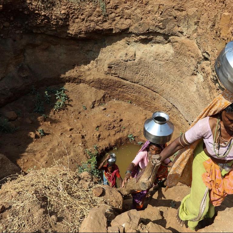 Bewohner eines Dorfes nahe Nasik versuchen aus einem fast ausgetrockneten Brunnen Trinkwasser zu holen.