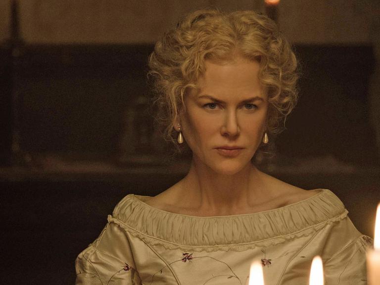 Schauspielerin Nicole Kidman sitzt in einer Filmszene vor Kerzen.