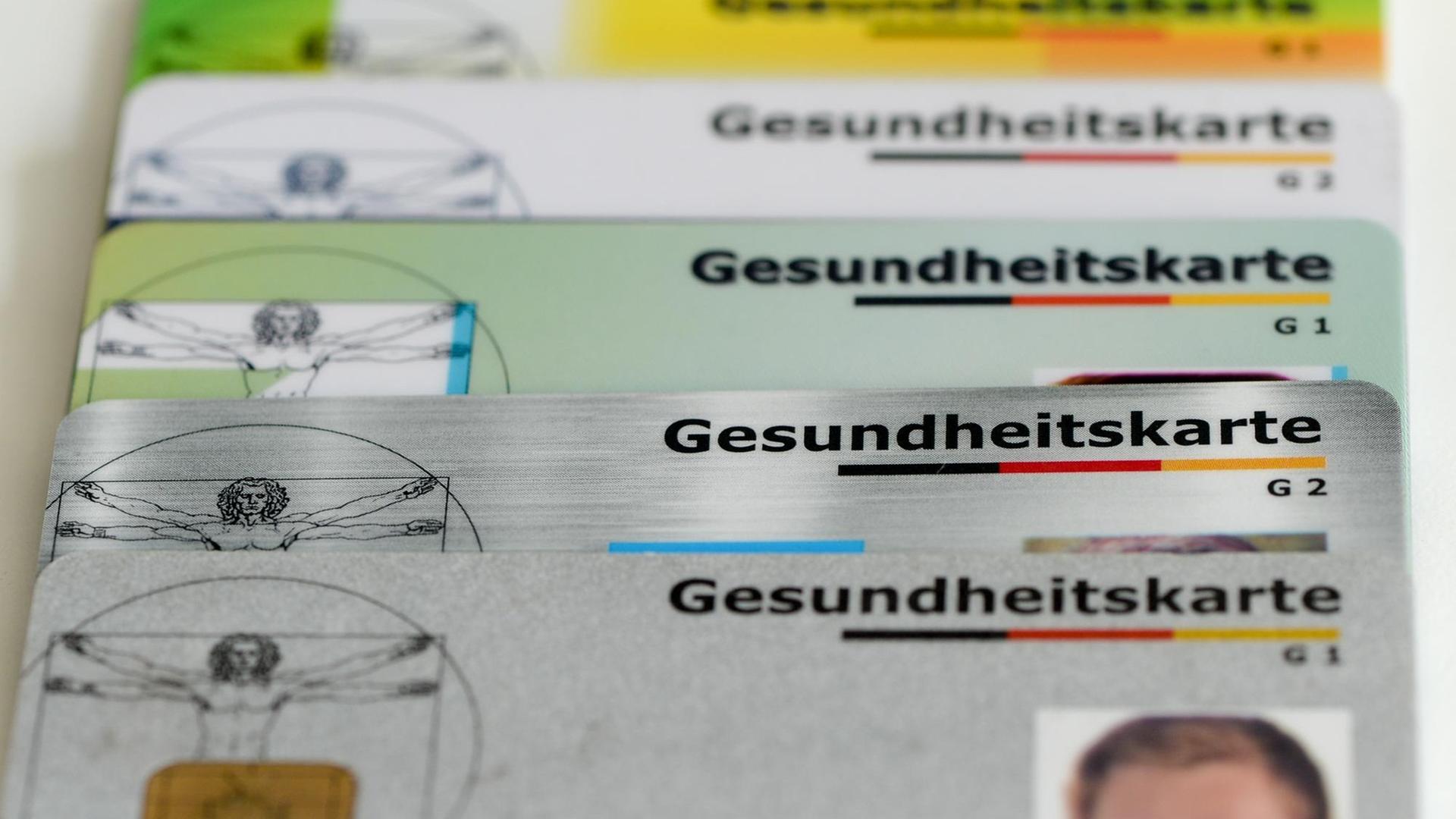 Gesundheitskarten verschiedener Krankenkassen liegen auf einem Tisch Gesundheitskarten verschiedener Krankenkassen liegen auf einem Tisch