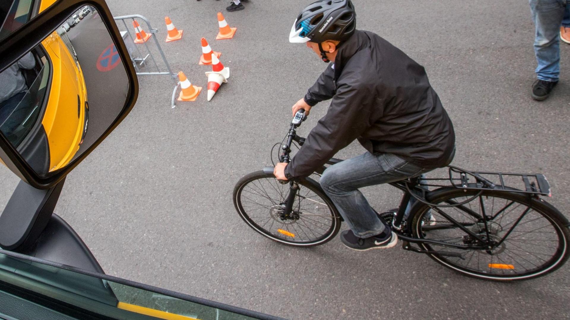 Ein Fahrradfahrer fährt während einer Demonstration des neuen Abbiegeassistenten neben einem Lastwagen.