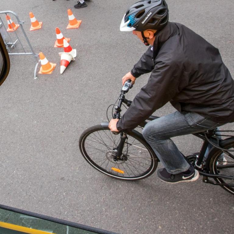 Ein Fahrradfahrer fährt während einer Demonstration des neuen Abbiegeassistenten neben einem Lastwagen. 