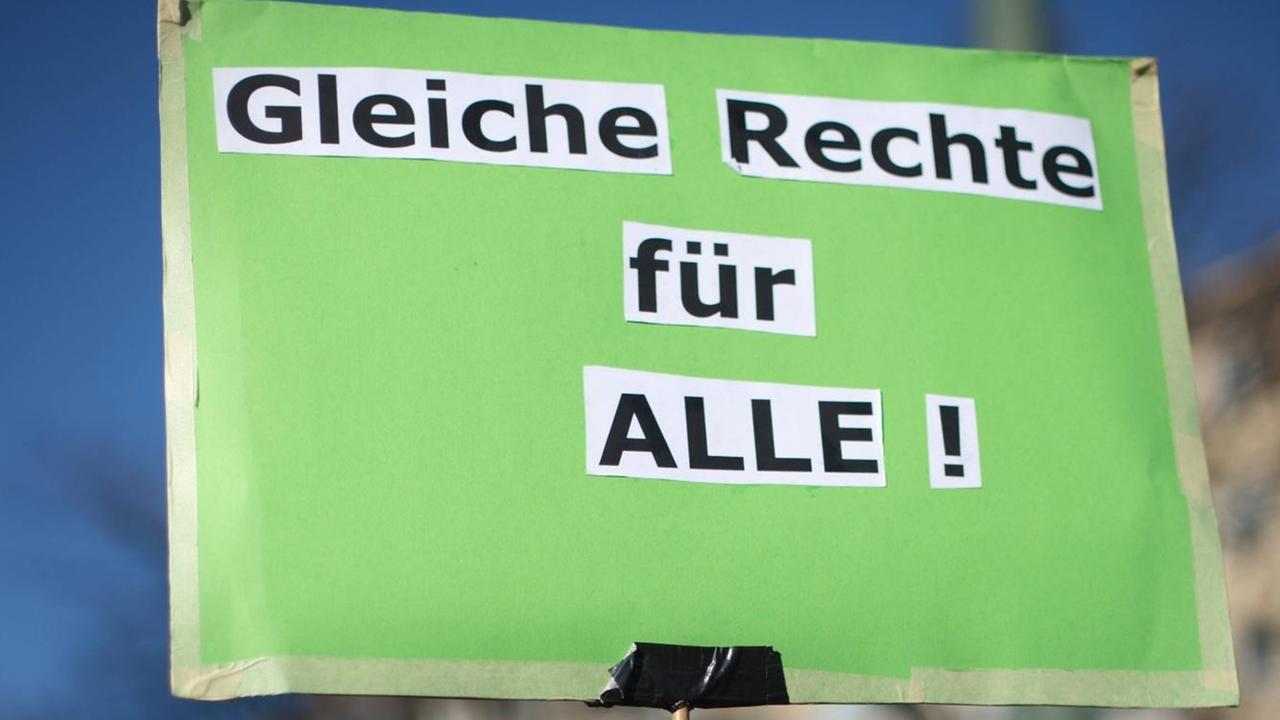 Hellgrünes Schild einer Demonstrantin mit den aus einer Zeitung ausgeschnittenen und aufgeklebten Worten: "Gleiche Rechte für ALLE !" Hellgrünes Schild einer Demonstrantin mit den aus einer Zeitung ausgeschnittenen und aufgeklebten Worten: "Gleiche Rechte für ALLE !"