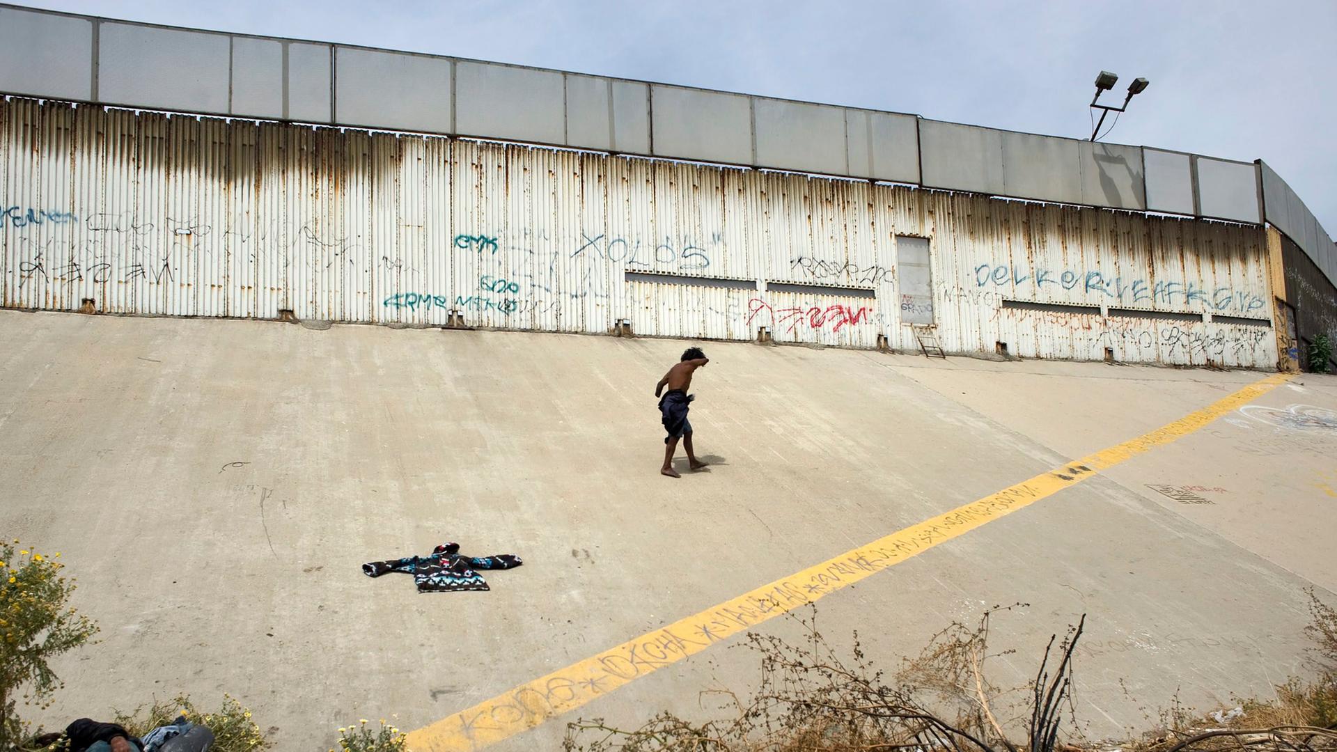 Ein obdachloser Migrant vor der US-mexikanischen Grenze in Tijuana, Mexiko. Ein obdachloser Migrant vor der US-mexikanischen Grenze in Tijuana, Mexiko.