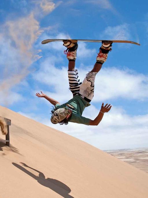 Sandboarder in den Sanddünen der Namib Wüste.