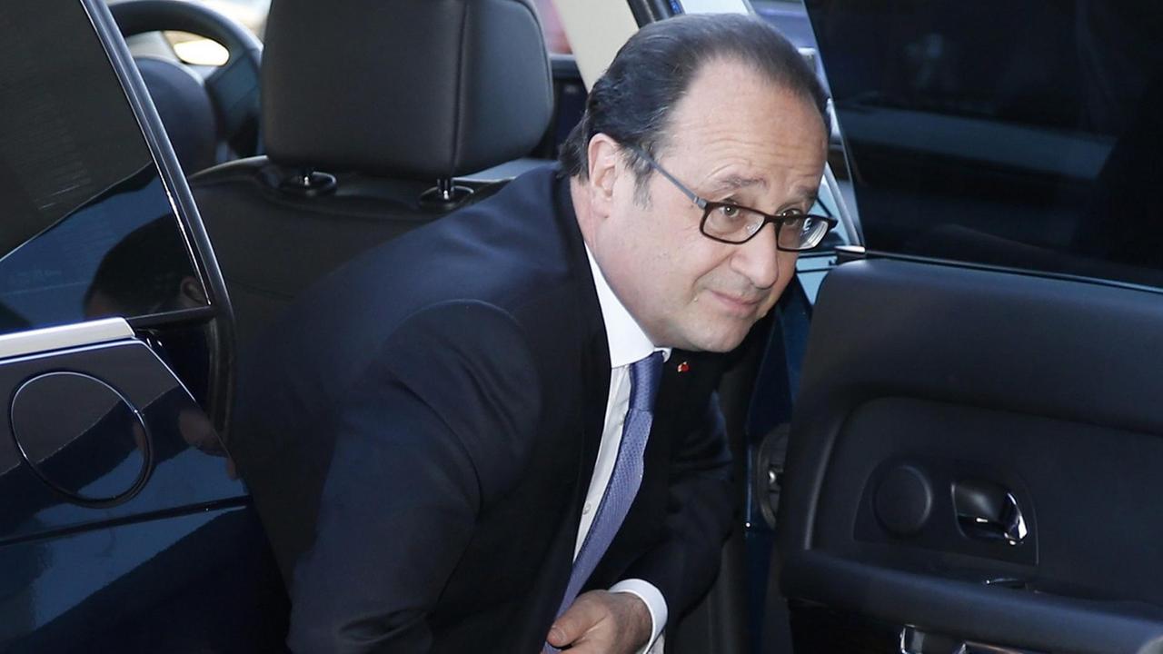 Hollande steigt im schwarzen Anzug mit blauer Krawatte aus einem Auto. Hollande steigt im schwarzen Anzug mit blauer Krawatte aus einem Auto.