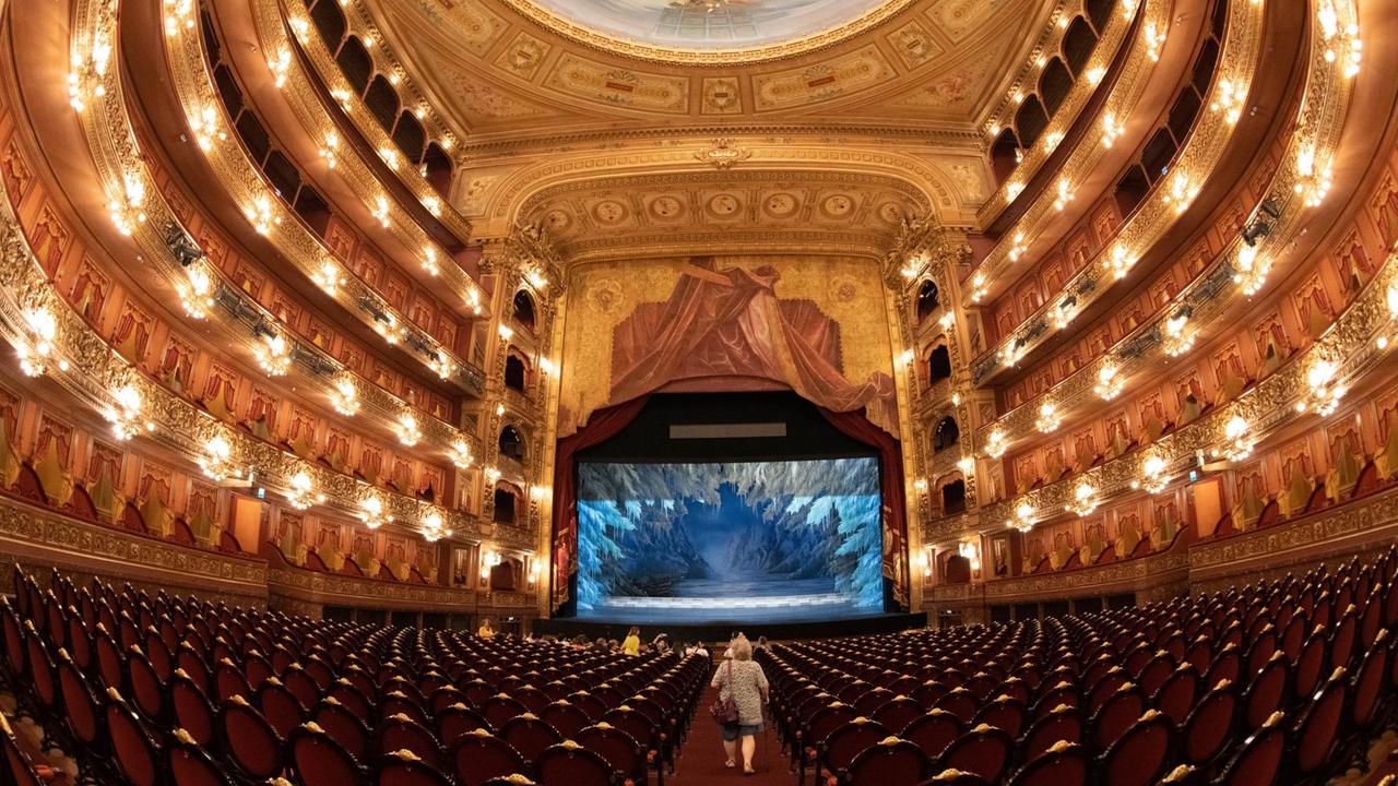 Blick in den grandiosen Zuschauerraum mit mehreren Rängen und großem Parkett, das rote Stühle hat, vom Teatro Colón in Buenos Aires. 